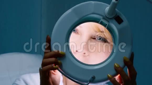 从美容诊所的放大镜看的女人视频的预览图