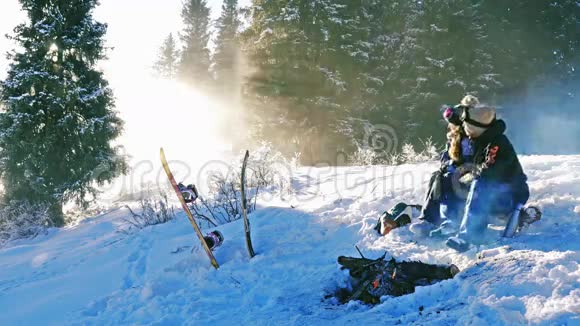 滑雪者夫妇在户外篝火旁热身山上视频的预览图
