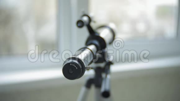 一个小女孩从她家的窗户透过望远镜看视频的预览图
