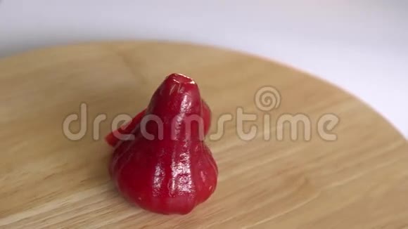 新鲜的红玫瑰苹果在木桌上旋转视频的预览图