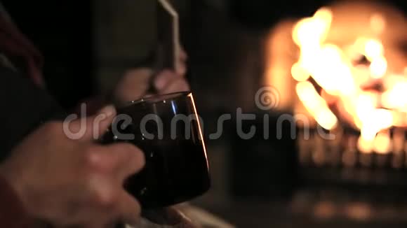 坐在壁炉前喝茶的老人视频的预览图