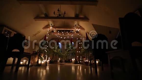 美丽的圣诞冬季婚礼拱门在订婚装饰内部与蜡烛桦木原木灯泡花环和冷杉视频的预览图