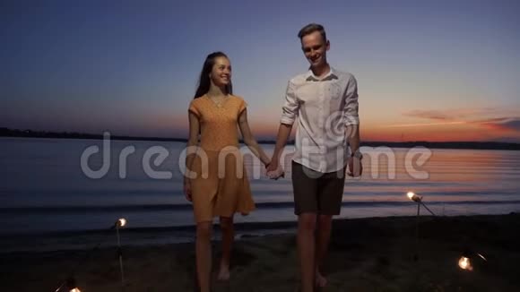 日落时分一对夫妇沿着码头在海上漫步视频的预览图
