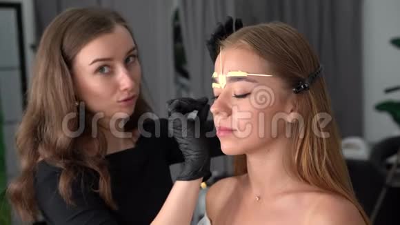 年轻美容师白种人女孩举着模特修眉视频的预览图