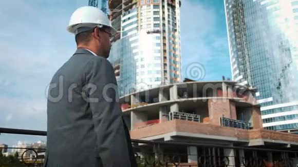 工程师或建造者检查和控制在建物他经过建筑工地视频的预览图