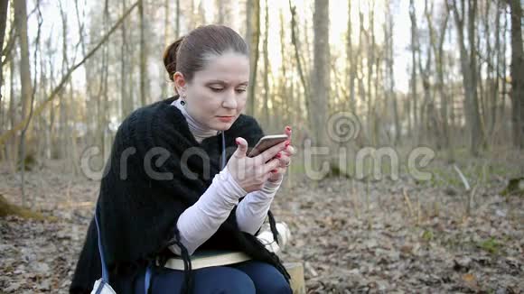 坐在公园里看短信的女孩视频的预览图