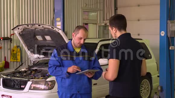 汽车机械师在车库里用平板电脑诊断汽车视频的预览图