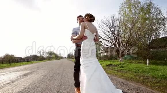 新娘和新郎拥抱在路上视频的预览图