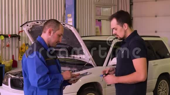 机械师在车库里做汽车测试时使用数字平板电脑视频的预览图