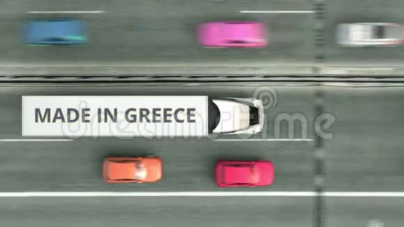 飞机从上往下看拖车卡车与希腊制造文本沿道路行驶与希腊商业有关的循环视频的预览图
