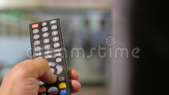 一个人手握着电视上的遥控器开关频道特写镜头移动摄像机视频的预览图