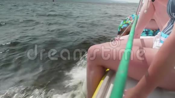 女性双腿悬在白色帆船的侧面视频的预览图