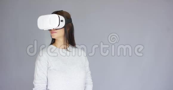 兴奋的女人看着她的虚拟现实头盔上的东西视频的预览图