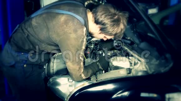汽车维修站引擎盖下装有扳手的汽车修理工视频的预览图
