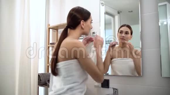 皮肤护理女人摸脸看镜子看浴室视频的预览图