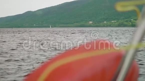 从船尾到白帆船在木山背景下的景色视频的预览图