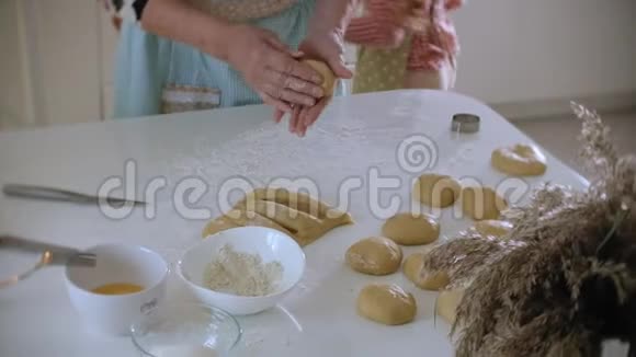 小女孩和奶奶站在厨房里用面团做饼干视频的预览图