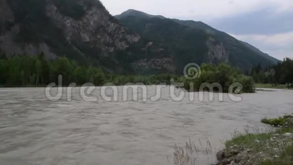 湍急的水流在山河沿着河岸的岩石视频的预览图