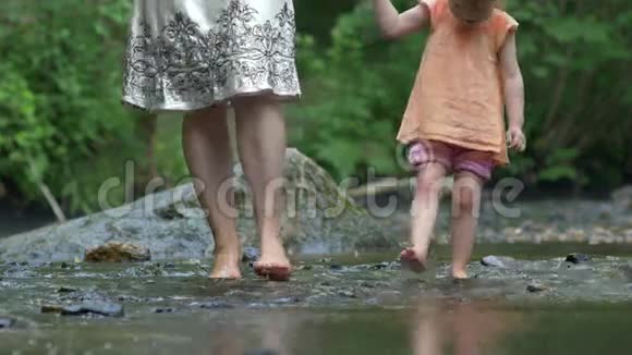母亲和小女儿光着脚在岩石上划桨视频的预览图