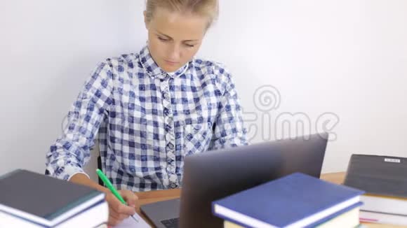 年轻女子在笔记本电脑后面工作视频的预览图