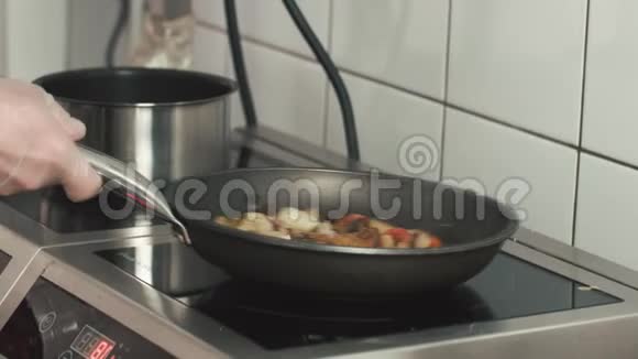 厨师在煎锅里用蘑菇烤蔬菜厨师准备素食视频的预览图