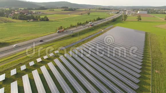 农业景观公路旁太阳能发电厂的无人机天线视频的预览图