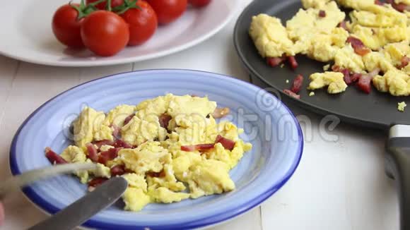 用餐盘中的叉子和刀子吃的炒鸡蛋和培根视频的预览图