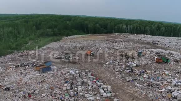 日落时俯瞰巨大的城市垃圾场垃圾车卸垃圾视频的预览图