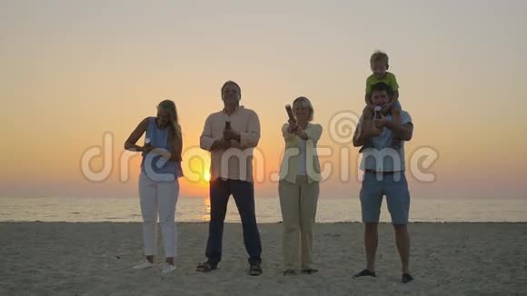 在海滩上用彩纸庆祝家庭视频的预览图