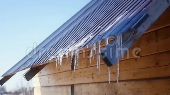 木屋屋顶上美丽的冰柱隐藏在春天的阳光下高清1920x1080下面的动作视频的预览图