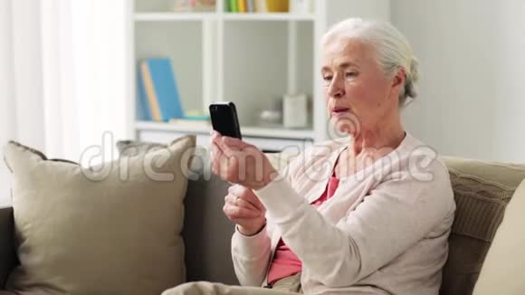 有智能手机的老妇人在视频聊天视频的预览图