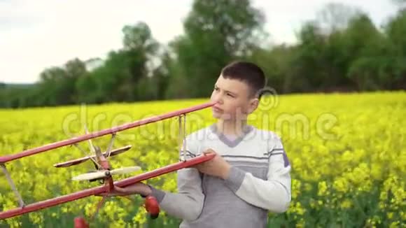 英俊的孩子拿着自制的飞机在背景上微笑4K视频的预览图