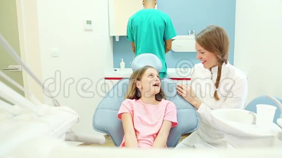 女牙医与年轻病人谈话助理做常规检查视频的预览图