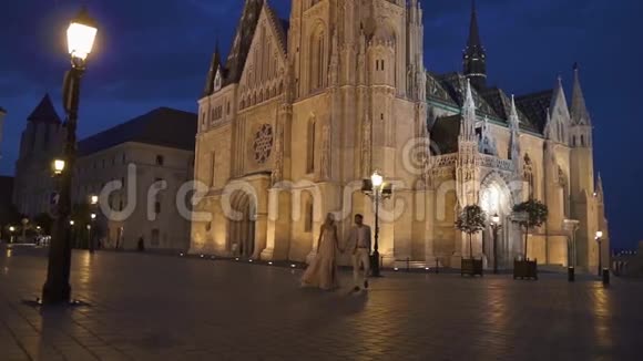 华丽的新婚夫妇在炎热的夏夜在壮丽的布达佩斯浪漫地散步视频的预览图