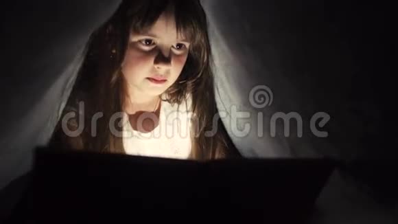 女孩在毯子下面使用平板电脑视频的预览图