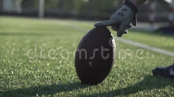 球场上橄榄球的特写镜头抓住了一个男人手视频的预览图