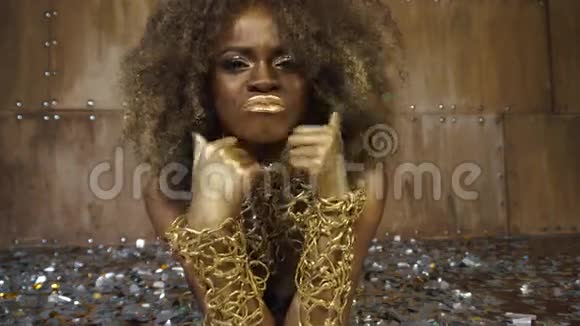 非洲裔美国女性模特的超现实创作肖像躺在地板上金色光泽的妆容被包围着视频的预览图