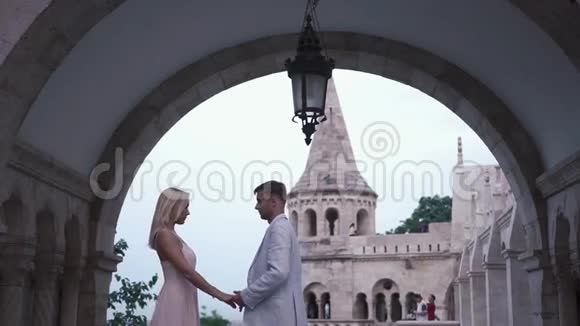 在匈牙利布达佩斯的宏伟城堡里一对相爱的情侣轻轻拥抱在一起蜜月概念视频的预览图