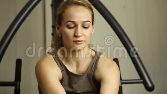 年轻女子参加体育运动在健身房健身拿着哑铃做运动的女孩视频的预览图