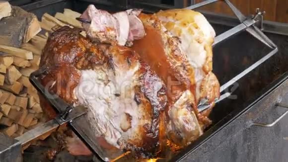 在明火上方的烤架上准备的大块肉肉烤腿捷克共和国布拉格的街头美食视频的预览图