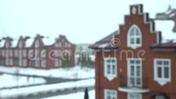 雪花飘落在模糊的红砖小屋上的超慢动作镜头视频的预览图