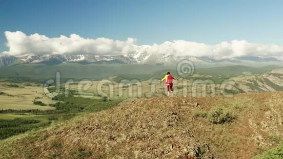 女徒步旅行者在山顶上的空中射击视频的预览图