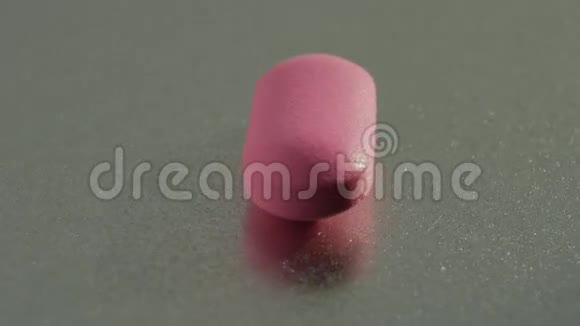 粉红色的药丸在金属表面旋转视频的预览图