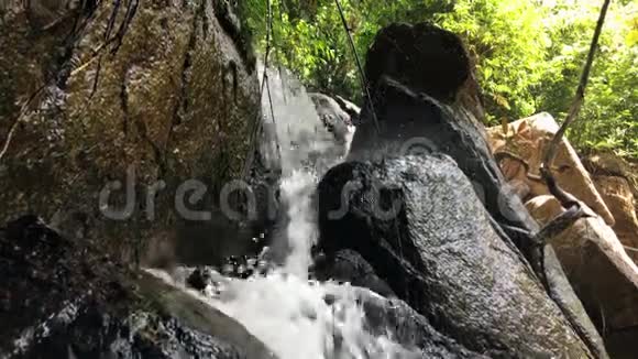 热带森林中的小瀑布在岩石上盘旋高清慢镜头泰国视频的预览图
