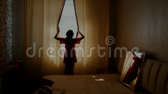 年轻女子在卧室里拉开窗帘视频的预览图