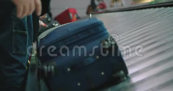 从机场传送带上收集行李的乘客视频的预览图