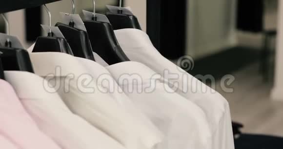 一排男士西装外套和衣架上的衬衫视频的预览图