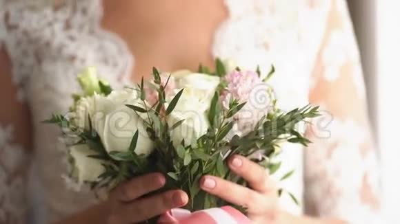 新娘带着结婚花束望着窗外对着镜头微笑视频的预览图