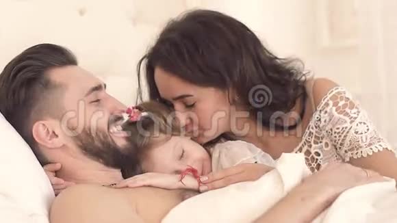 快乐的一家人在床上醒来可爱的小女儿视频的预览图