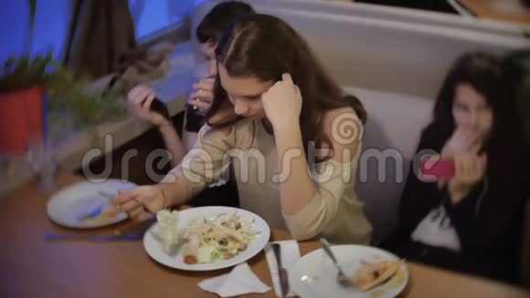 少女在快餐店吃沙拉一群朋友坐在咖啡馆的室内晚餐视频的预览图